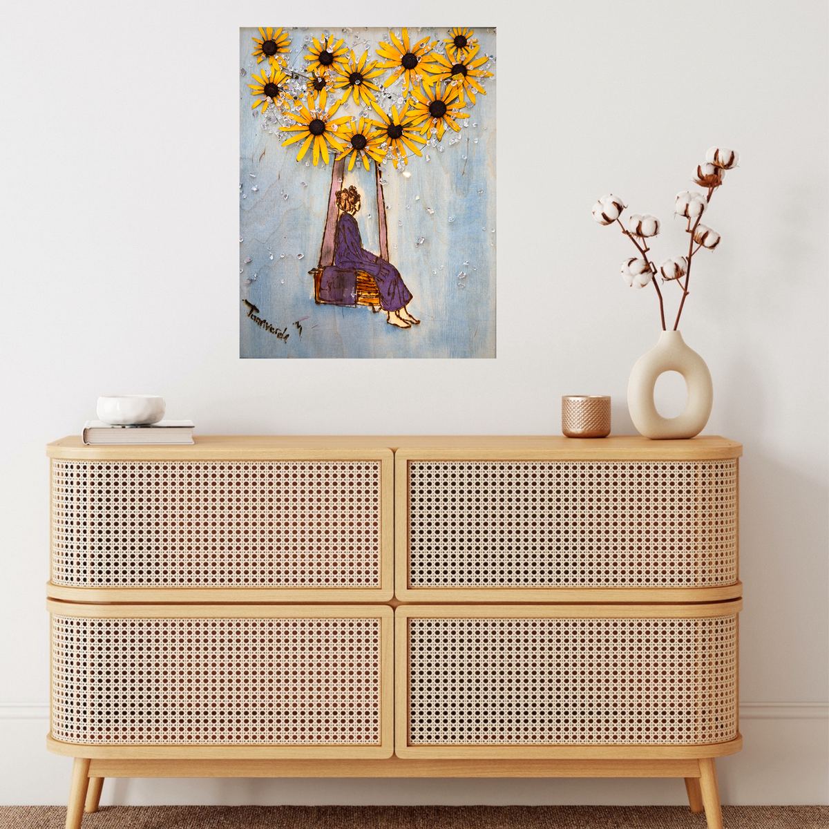 GLORY – Das Kunstwerk im Raum. Eine Frau auf einer Schaukel unter Sonnenblumen, hinter Acrylglas an einer warmen Wand.